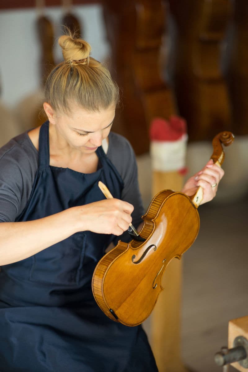 Ecaterina Simon applying varnish to a violin